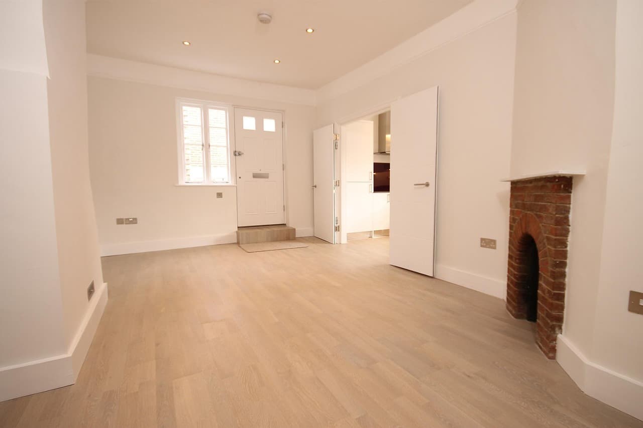 Freshly finished living room with white walls, a smooth ceiling and a brick fireplace