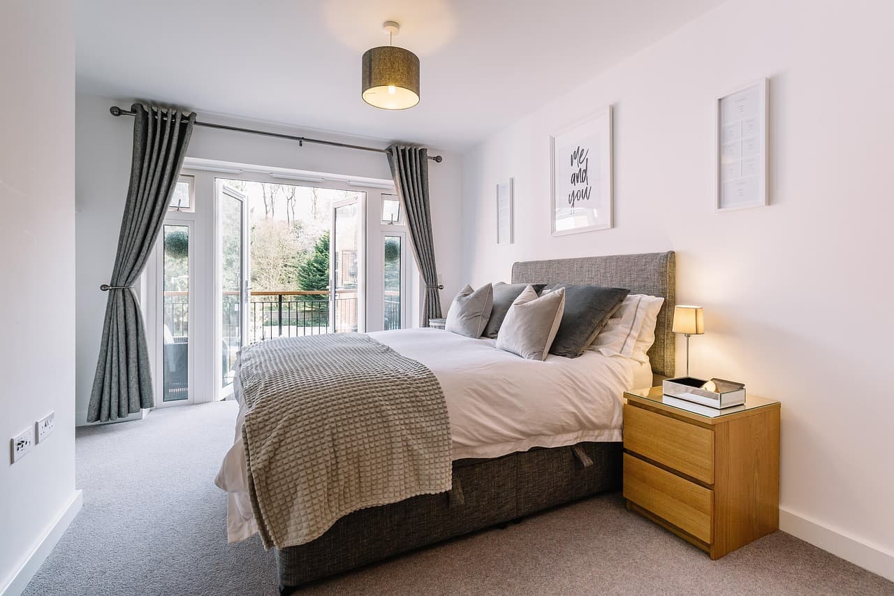 Bright bedroom with a smooth white ceiling and a pendant light
